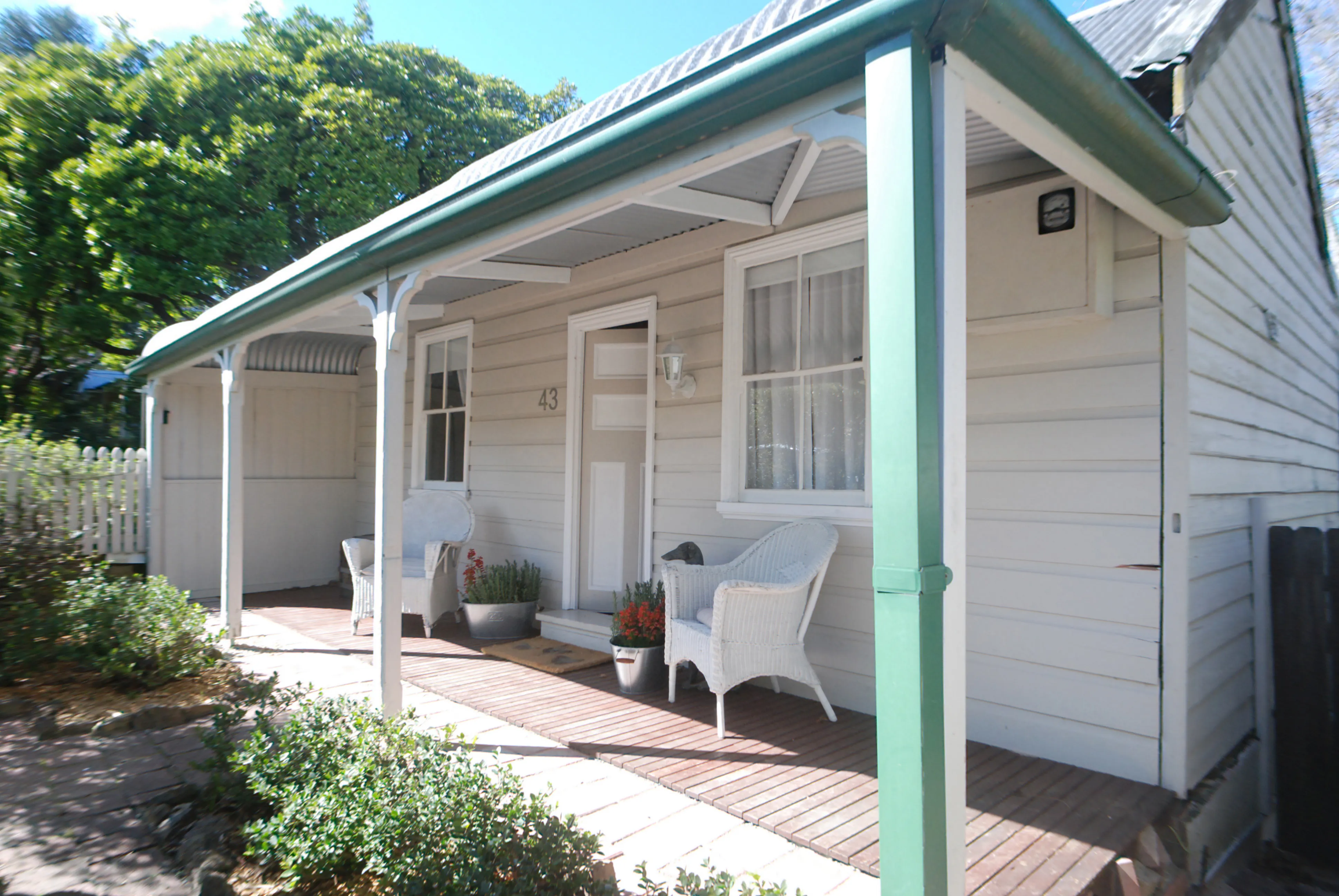 The white weatherboard verandah of Illalangi Boutique Cottage, Blackheath