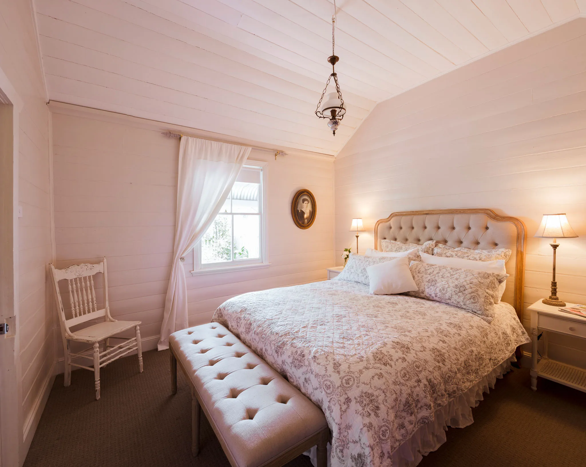 Queen bedroom with tufted linen headboard and bedside lamps